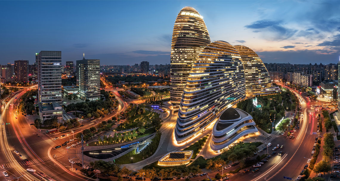 Image of office buildings lit up in evening